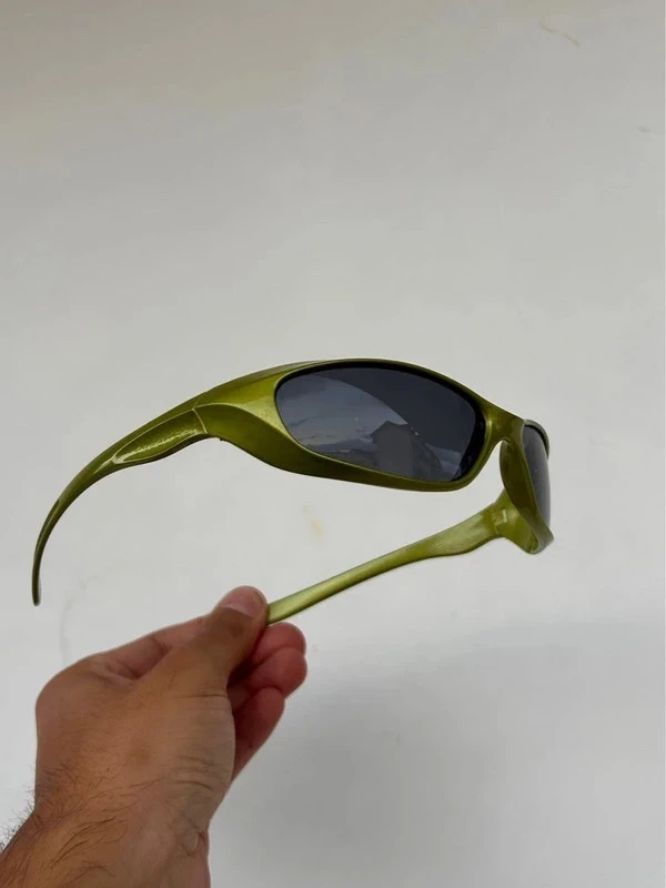 Photo source, lunettes vertes tenues à la main, profil